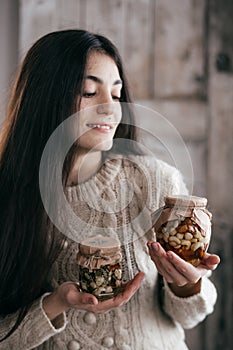 Beautiful girl a girl with jars in which honey and nuts