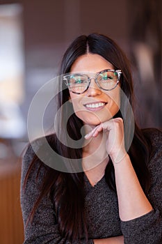 Beautiful girl with glasses. Portrait of a smart businesswoman in a reataurant
