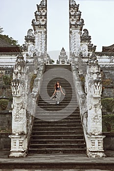 Beautiful Girl Going Down Stone Stairs From Gates Of Heaven In Pura Lempuyang Temple In Bali, Indonesia.