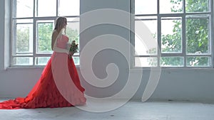 Beautiful girl in gorgeous red dress walking past