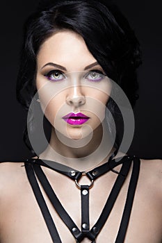 Beautiful Girl in the Gothic style with leather accessories and bright makeup. Beauty face.