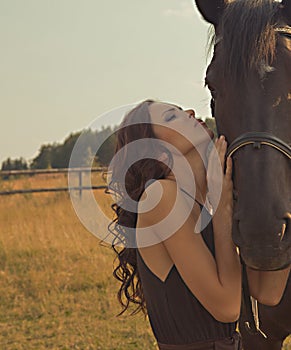 Beautiful girl in a gown with horse