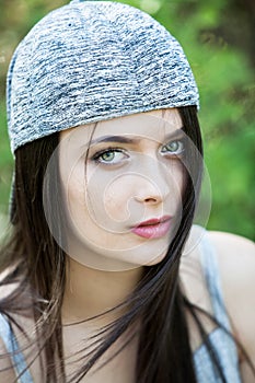 Beautiful girl with green eyes in city park. Woman beauty face portrait