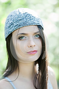 Beautiful girl with green eyes in city park. Woman beauty face portrait