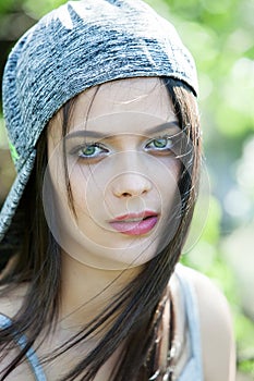 Beautiful girl with green eyes in city park. Woman beauty face portrait