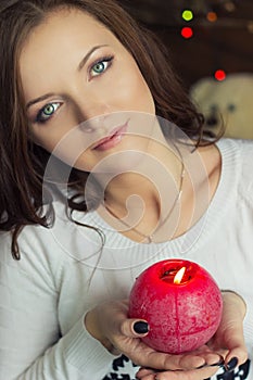 beautiful girl with green eyes with a red candle in his hand