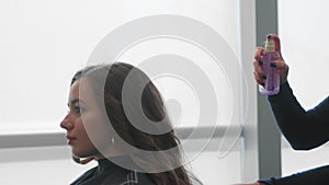 Beautiful girl at the hairdresser. The girl is getting her hair done. Beauty salon