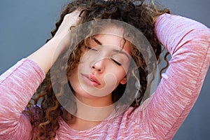 Beautiful girl with hands in hair and eyes closed