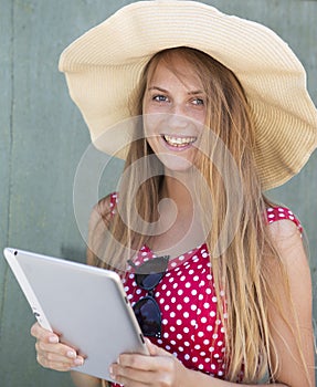 Beautiful girl in hat holding tablet computer in hand