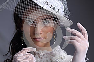 Beautiful girl in a hat with a veil of the XIX century
