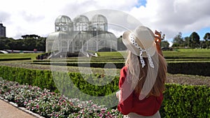 Beautiful girl with hat visiting the Botanical Garden of Curitiba, Parana, Brazil. Slow motion