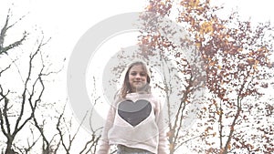 Beautiful girl having fun throwing leaves in the air