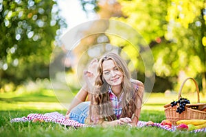 Beautiful girl having a picnic in park.