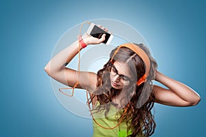 Beautiful girl in headphones listening to music and dancing