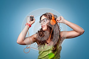 Beautiful girl in headphones listening to music and dancing