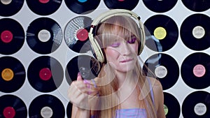 Beautiful girl in headphones sings. Singer, dj