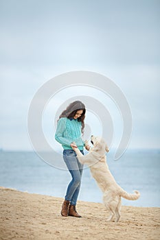 Beautiful girl with her dog near sea