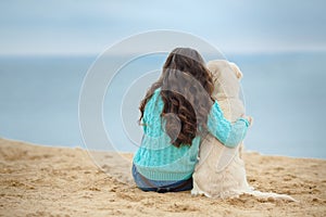 Beautiful girl with her dog near sea