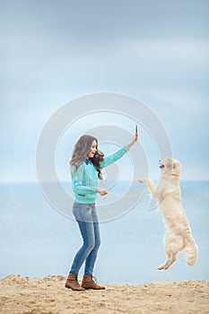 Beautiful girl with her dog near sea