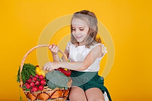 Beautiful girl holding a basket of ripe vegetables healthy food