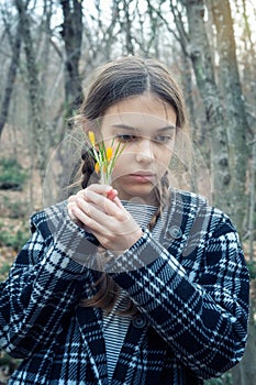 Beautiful girl holding a bouquet of yellow crocuses