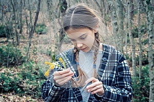 Beautiful girl holding a bouquet of yellow crocuses