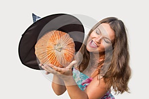 Beautiful girl holding halloween pumpkin with witch hat