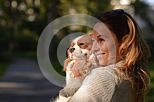 Beautiful girl holding her dog Cavalier King Charles Spaniel