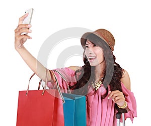 Beautiful girl holding shopping bags and taking selfie
