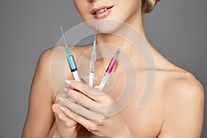 Beautiful girl holding syringes