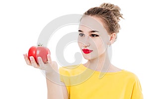 Beautiful girl holding a tomato in her hands, on a white isolated background. The concept of a healthy diet and diet.