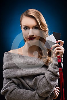 Beautiful girl holds in hand gray calibration card