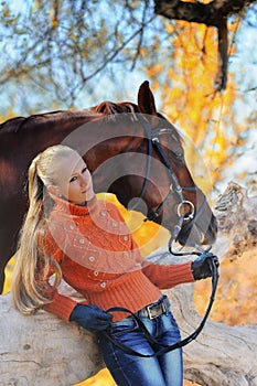 Beautiful girl with horse in autumn forest