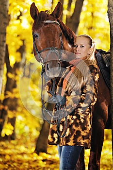 Beautiful girl with horse in autumn forest