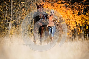 Beautiful girl with horse in autumn forest