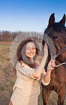 Beautiful girl with a horse outdoors.