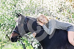 Beautiful girl and horse in spring garden