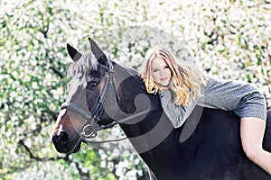 Beautiful girl and horse in spring garden