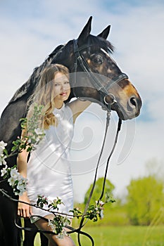 Beautiful girl and horse in spring garden