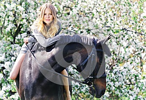 Beautiful girl and horse in spring garden