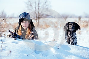 A beautiful girl hunter in camouflage suit with binoculars and a