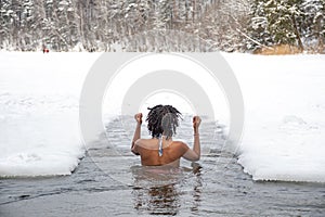 Beautiful girl on the ice enjoying winter in the cold water