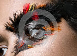 Beautiful girl in image of Phoenix bird with creative makeup. beauty face. Close up