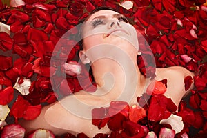 Beautiful girl in jacuzzi with rose petal.