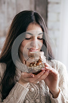 Beautiful girl with jars in which honey and nuts