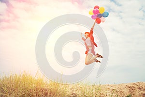 Beautiful Girl jumping with balloons on the beach