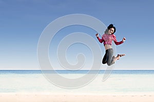 Beautiful girl jumping at beach