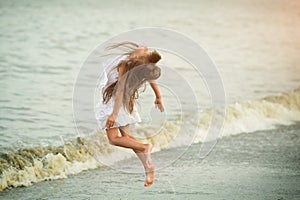 Beautiful girl jumping through the waves