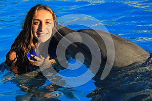 Beautiful girl kissing a gorgeous dolphin flipper smiling face happy kid swim bottle nose dolphins