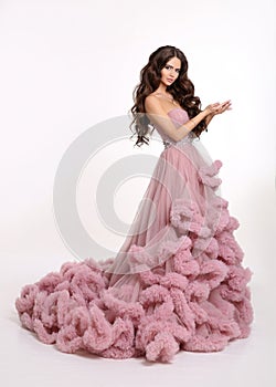 Beautiful girl Lady in luxury lush pink dress. Fashion brunette